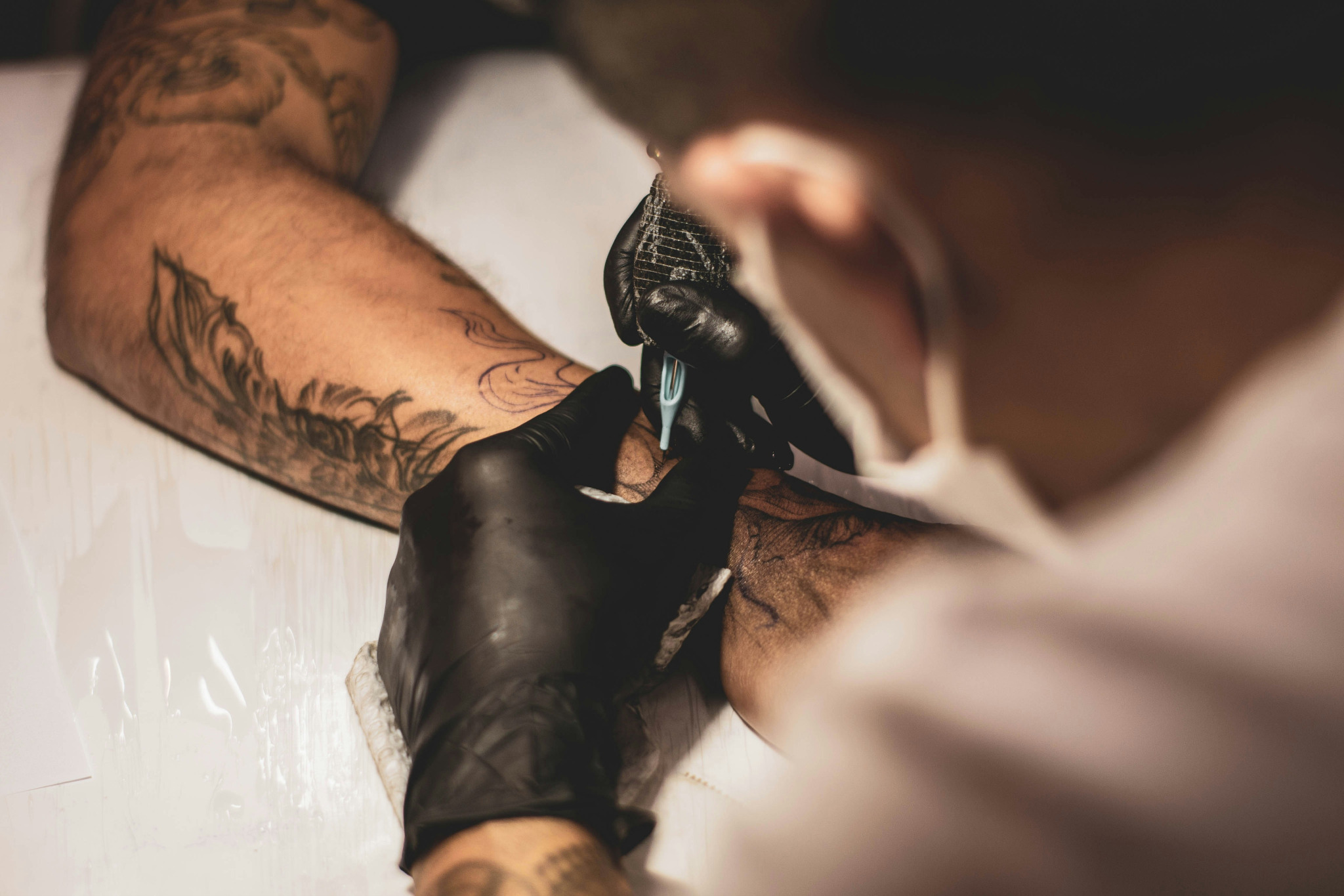 Tattoo artist working with a client